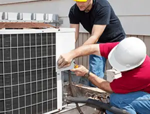 HVAC technicians repairing an outdoor AC unit on a rooftop in Hoboken, NJ